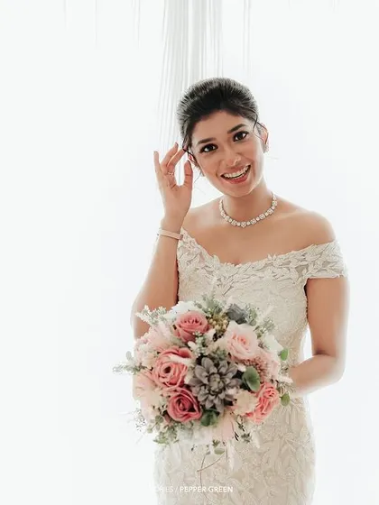 A bright, high-key portrait of the bride, her happy smile the central focus against a clean white background.