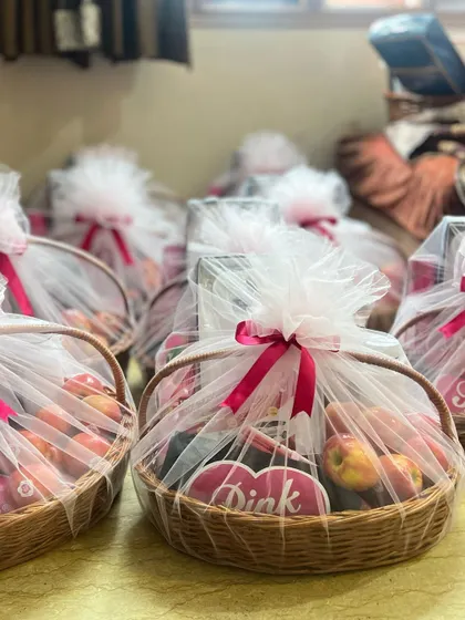 A row of wrapped 'Pink Lady' gift baskets, ready for a corporate event or employee appreciation day.