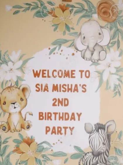 A close-up of the welcome sign for Sia and Misha's jungle-themed second birthday party. The cute, illustrated baby animals perfectly matched the gentle and fun "Wild One" vibe.