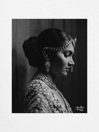 A classic black and white side profile portrait, highlighting the bride's elegant hairstyle and jewelry.