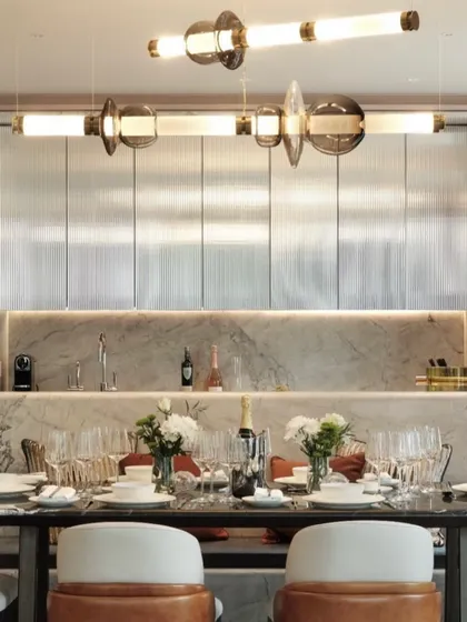 The Luna series provides elegant illumination over a formal dining table. The combination of illuminated tubes and decorative glass elements adds a layer of glamour and sophistication.