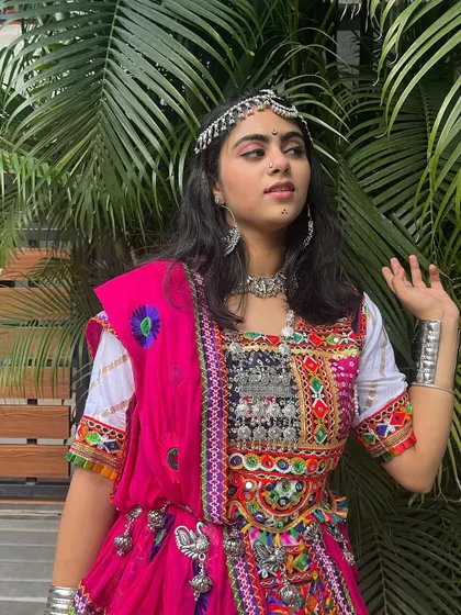 A close-up of the white and pink chaniya choli, highlighting the silver-toned blouse and matching oxidized jewelry.