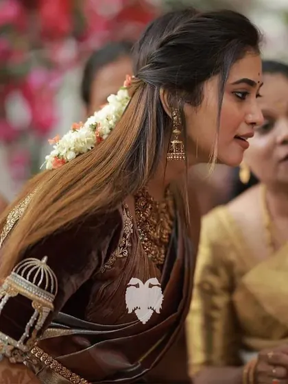 Bride Priyanka Suresh in a Katori-draped maroon velvet blouse with unique Jharokha-inspired sleeves.