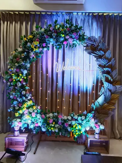 A full circular floral arch with a "Welcome" neon sign. This versatile piece is perfect as a photo backdrop or an entrance for any celebration.
