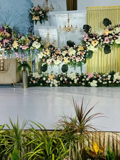 A wide view of a floral stage, showing how we use greenery and flowers to create a lush, garden-like setting indoors.
