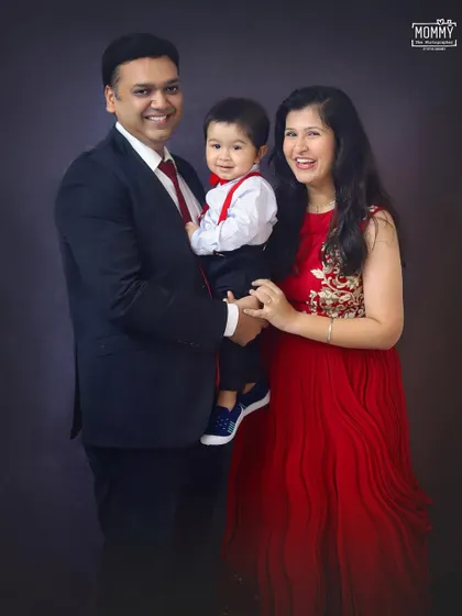 This family looks so happy and picture-perfect. The coordinating red and black outfits add a classic touch to their portrait.