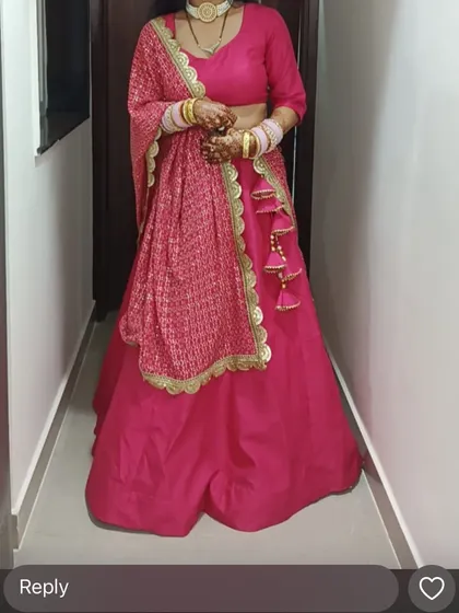 A full look at the custom pink lehenga. The blouse has a classic cut, and the dupatta features beautiful tassel details, adding a touch of playfulness to the elegant ensemble.