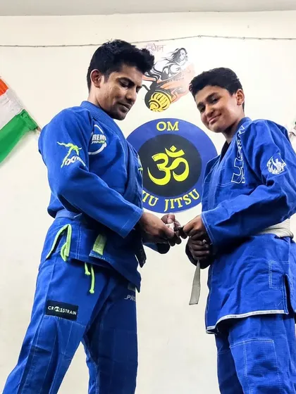 The moment a student's hard work is recognized. I am awarding a stripe to a young BJJ practitioner, marking his progress and commitment to the art.