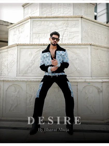 Seated with an air of authority, this image showcases the unique design of the denim patchwork co-ord set. It's a look that is both rugged and refined.