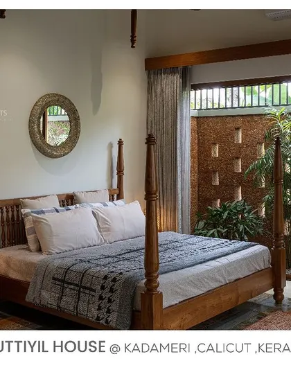 A classic four-poster bed brings a touch of heritage to this bedroom in Kuttiyil House, which opens onto a courtyard with a traditional jali wall.
