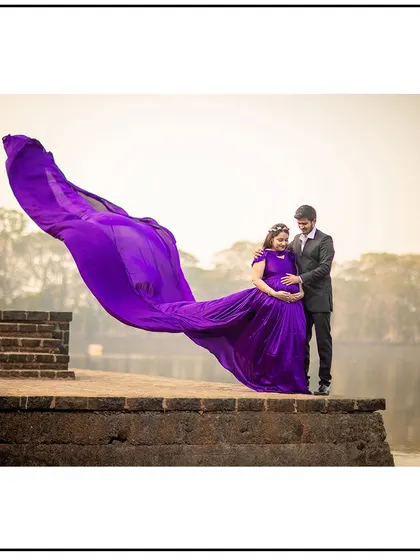 A stunning lakeside portrait with the wind catching the vibrant purple gown, creating a breathtaking effect.