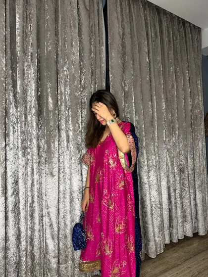 A candid shot of the pink kaftan, showing the beautiful fabric and drape against a simple background.