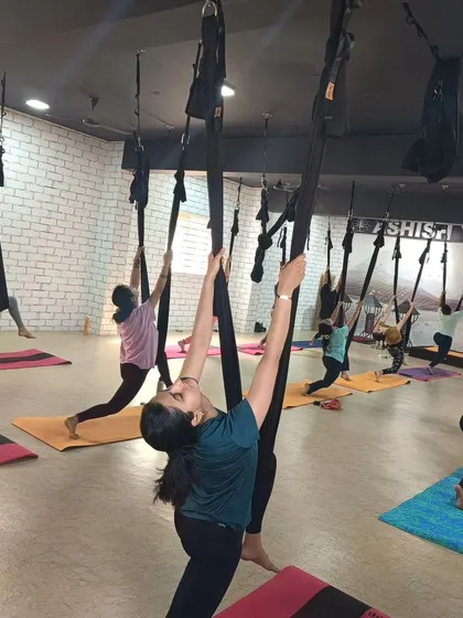 Students use the aerial silks to deepen a lunge stretch, allowing for greater hip flexibility and a full-body opening.