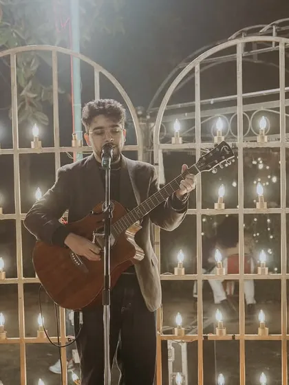 Performing solo against a beautifully lit backdrop. This kind of setup is great for creating an intimate and romantic atmosphere during a wedding dinner or cocktail hour.