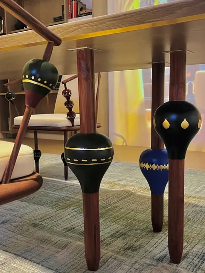 A detail shot of the custom dining chairs featured at a design event. The legs are adorned with hand-painted, lathe-turned wooden beads inspired by traditional Channapatna toys, showcasing our commitment to integrating local craft into contemporary design.