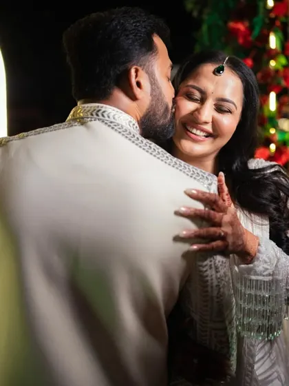 A warm embrace and a happy smile, capturing the love between the newlyweds.