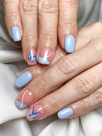 An overlay on natural nails, showing that you can have beautiful, detailed art without extensions. This set features a lovely periwinkle blue and hand-painted butterflies.