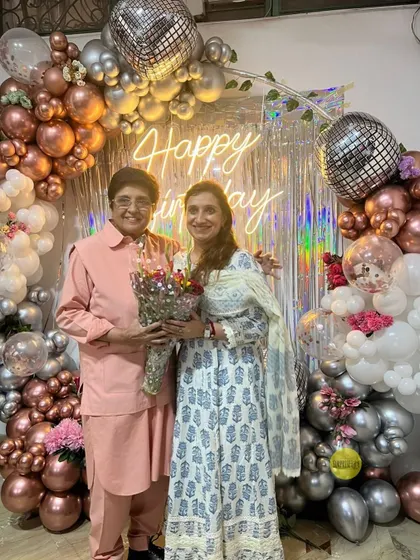 A full view of the beautiful decor for Kiran Bedi's birthday. We created a shimmering arch with rose gold, silver, and white balloons, complete with disco balls for a touch of sparkle.