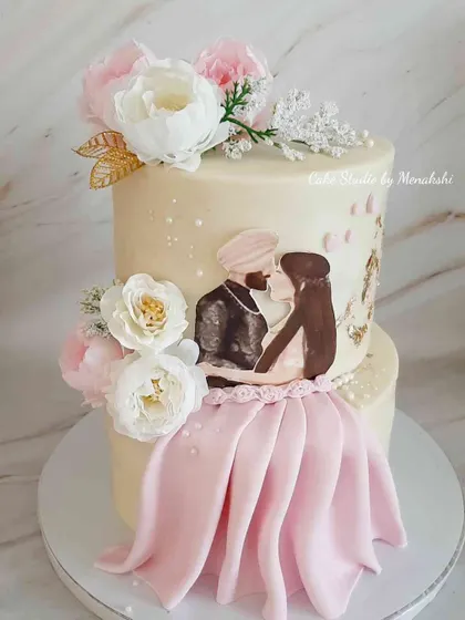 I love creating cakes that tell a couple's story. This hand-painted engagement cake was designed for a Sikh couple, featuring a beautiful portrait and delicate floral arrangements on a two-tier buttercream canvas.
