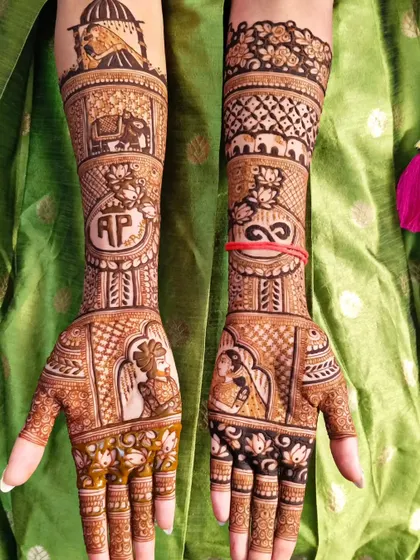 This personalized bridal mehndi includes the couple's initials, portraits, and an infinity symbol. The design also features elephants and other traditional motifs for a complete wedding story.