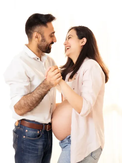 A playful and romantic moment. The couple holds hands and shares a laugh, creating a photo that is full of life and happiness.