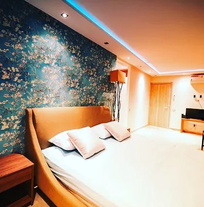 An elegant bedroom accent wall featuring a floral pattern with a textured finish. This technique adds a touch of sophistication and visual interest to personal spaces.