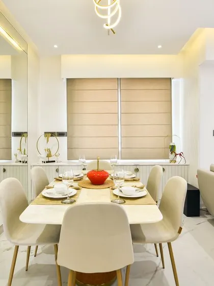 This view of the dining space highlights the warm beige tones and soft Roman blinds, creating a cozy and refined atmosphere perfect for intimate meals.