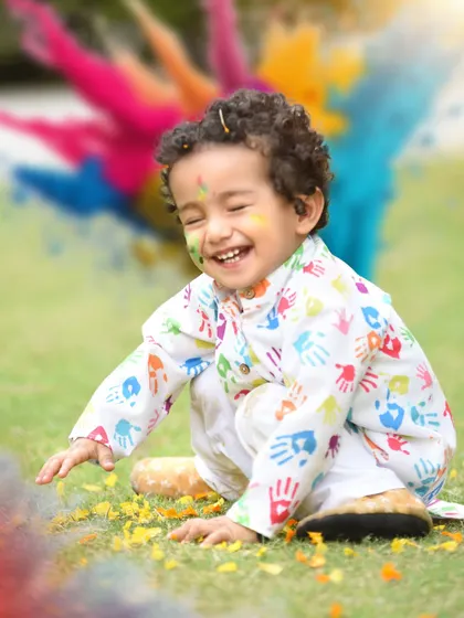 A candid laugh during a fun and messy Holi photoshoot. These outdoor sessions are all about capturing genuine moments of celebration.
