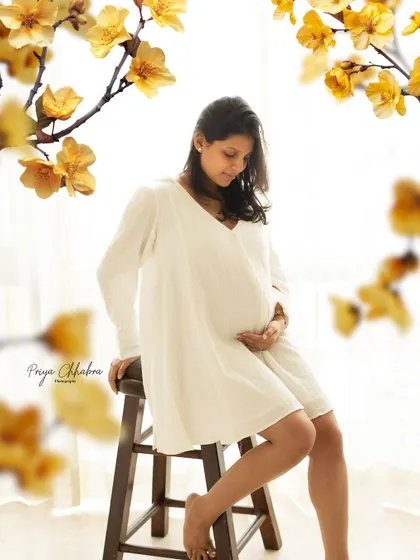 A quiet moment of anticipation. This portrait, framed by delicate yellow flowers, feels hopeful and full of warmth.