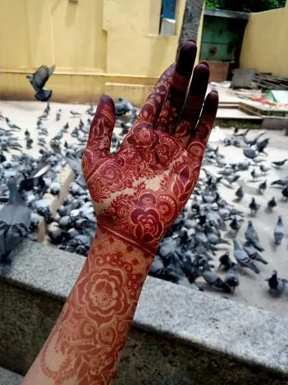 The deep red of the henna stain is clearly visible in this outdoor shot.
