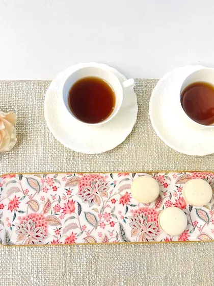 This long tray with a pink block-print inspired floral pattern is perfect for serving macarons or other delicate sweets. Its soft colors add a touch of gentle charm.