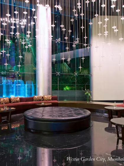 The dramatic, contemporary lobby of the Westin Garden City, Mumbai, with its signature waterfall. This venue is perfect for couples seeking a modern and sophisticated aesthetic.