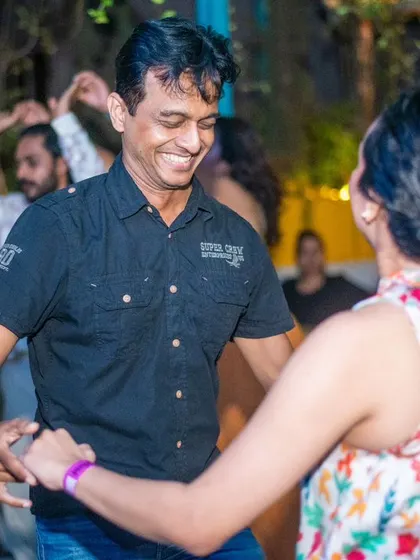 A happy and relaxed couple enjoying a dance together. The background lights create a lovely ambiance.
