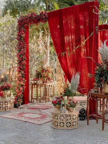 The grand entrance to the wedding, where a lush archway of red florals and dramatic draping set an opulent tone for the ceremony to follow.