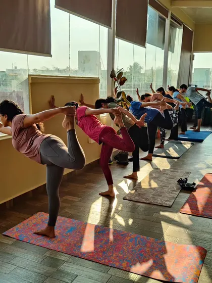 Students practicing Natarajasana (Dancer's Pose) in a line. It's beautiful to see the different expressions of the pose as each student finds their own balance and focus.