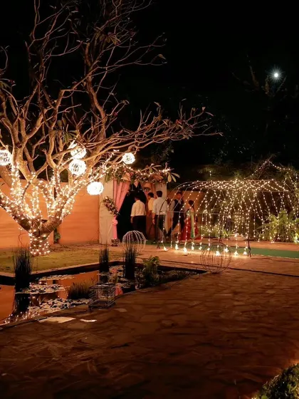 This wide-angle shot captures the overall ambiance of a magical outdoor wedding venue in Bengaluru. I used a combination of tree-wrapped fairy lights, glowing orbs, and a light tunnel to transform the space.