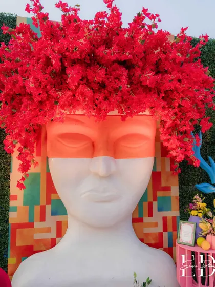 Art and nature collide in this striking installation featuring a stoic head sculpture crowned with a vibrant explosion of red bougainvillea. This piece exemplifies my approach of using unexpected combinations to create memorable focal points.