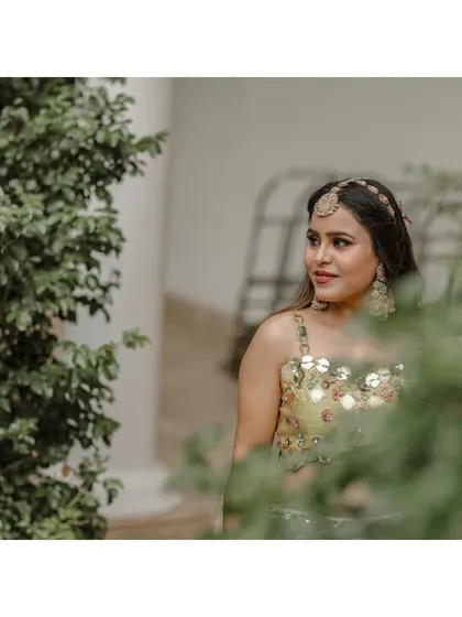 A candid portrait of the bride, peeking through the greenery.