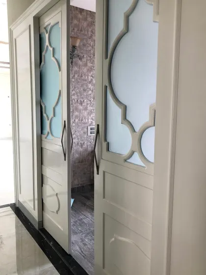 We designed this bespoke pocket door with an elegant geometric pattern to separate the formal living room and lounge. It's a functional solution that adds a touch of sophistication and custom detail.