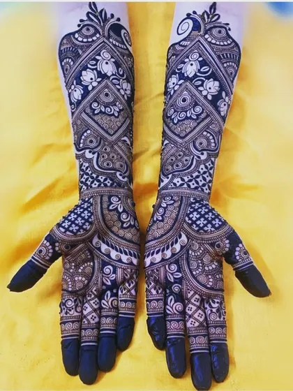 This is a perfect example of our intricate traditional work. The design uses negative space with bold lines to create a stunning contrast, featuring detailed floral and geometric patterns for a classic bridal look.