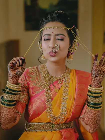 A playful and cute portrait of the bride showing off her traditional mundavalya.