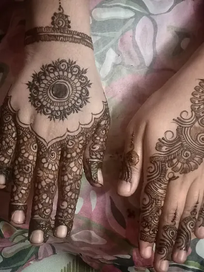 A lovely back-hand design combining a central mandala with a flowing Arabic pattern on the fingers.