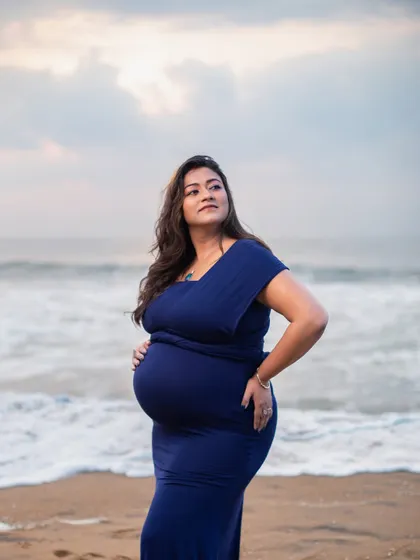 A portrait of strength and confidence. The mom-to-be looks out at the ocean, contemplating the beautiful journey of motherhood ahead.