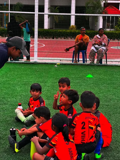 A coach sits down with the U7 team for a post-game chat, a crucial time for learning and reflection.