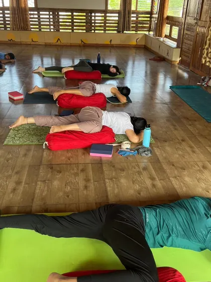 A row of students rests in a supported pose, showcasing the calm and meditative atmosphere of our Yin sessions.