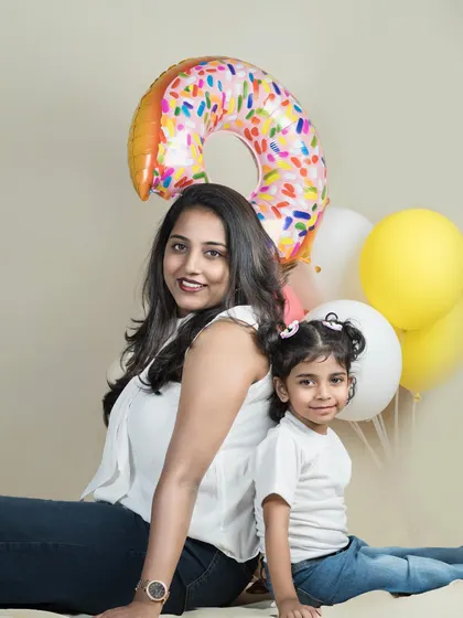 A duplicate of image 134, showing a mother and daughter celebrating a birthday with fun, colorful balloons.