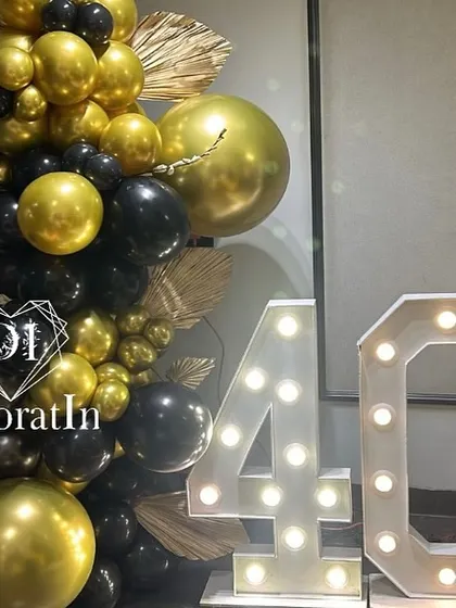 A corner detail from the lion-themed party, featuring a large marquee '40' next to a column of black and gold balloons.