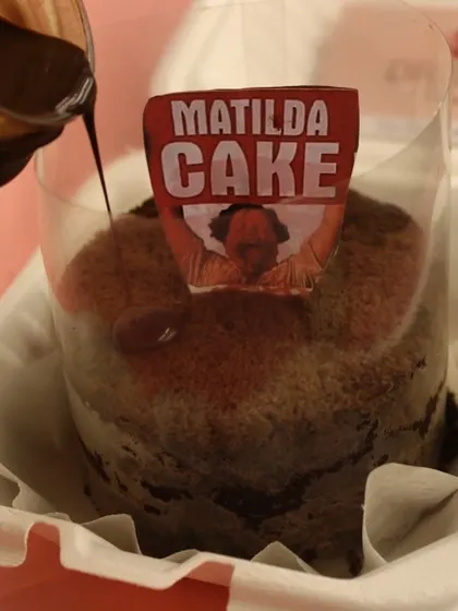 A close-up of our Matilda Cake being prepared, with the iconic label. This rich chocolate dessert is a must-try for any chocolate enthusiast.