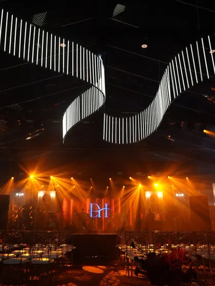 The stage and lighting setup for the Vietnam Sangeet. A custom monogram for the couple and dynamic lighting rigs transformed the space into a professional concert venue for one night.