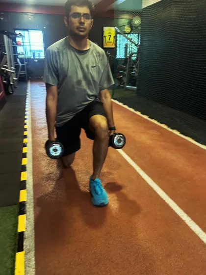 A client performs walking lunges with dumbbells, adding resistance to this classic conditioning move.